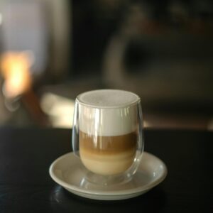 Products Stylish latte macchiato with layered coffee and milk foam in a modern double wall glass.
